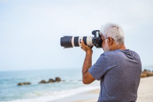 Photographer on beach with camera taking pictures