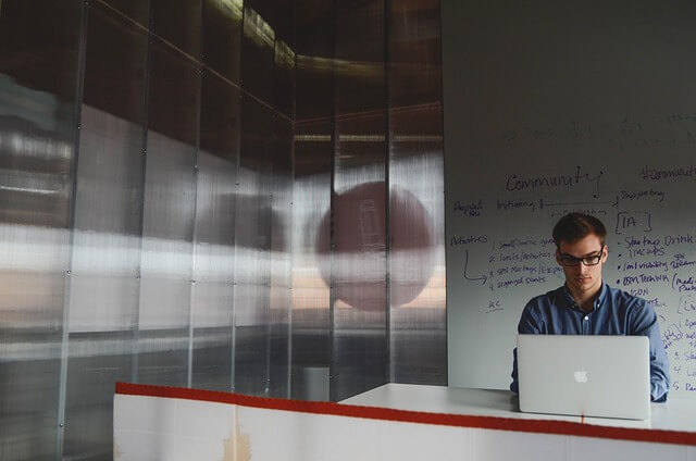 Man sitting in office working on laptop computer