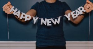 Woman holidng banner that reads "Happy New Year"