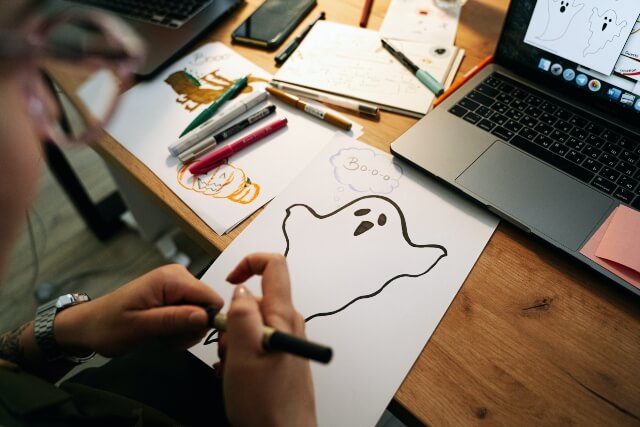Woman drawing ghost at computer