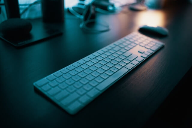 Keyboard sitting on desk in dark room