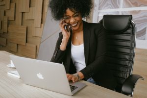 Woman talking on phone while working a a laptop computer