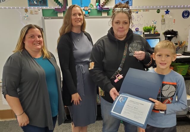 Media Specialist, Brandi Rohr receiving a glass trophy and certificate from student, Harper, and Custom Internet Services representatives, Stacey Higdon & Shaunna Shelton