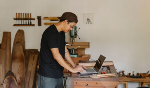 Small Business Owner in woodworking shop updating his Google Business Profile on his laptop