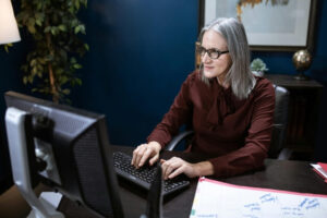 Older woman in a business office working on a computer