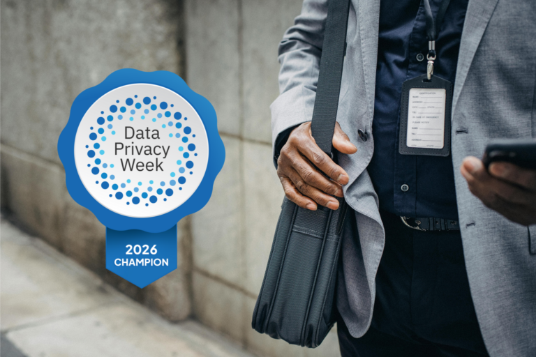 Close-up of man in a suite, holding a laptop bag and looking at his phone. A digital badge to the side of the man reads, "Data Privacy Week, 2026 Champion"