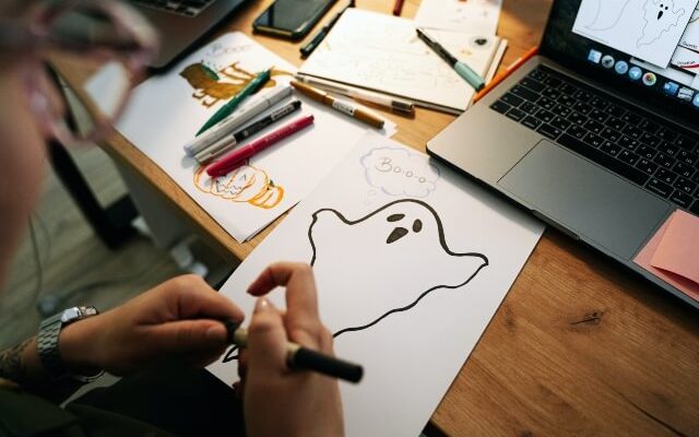 Woman drawing ghost at computer