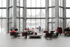 Employees in a large, open, glass atrium as part of an open work environment