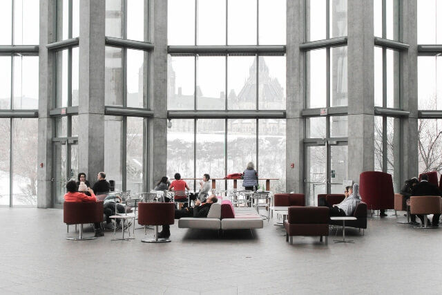 Employees in a large, open, glass atrium as part of an open work environment