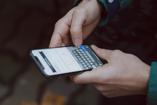 Closeup of two hands holding a smartphone open to email